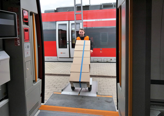 Der Mitarbeiter eines Paketdienstleisters belädt ein Schienenfahrzeug des ÖPNV. 